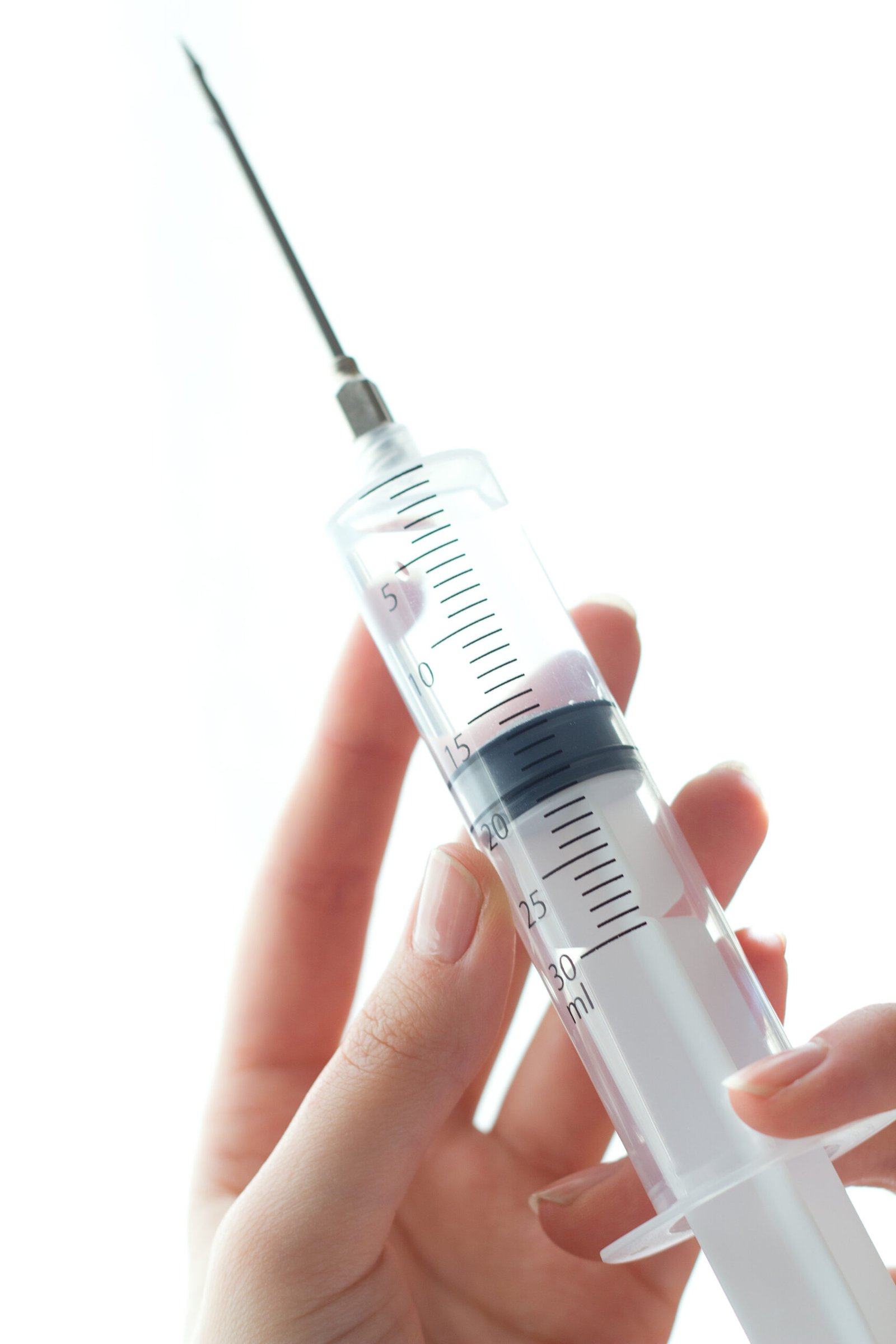 woman hand holding syringe isolated white